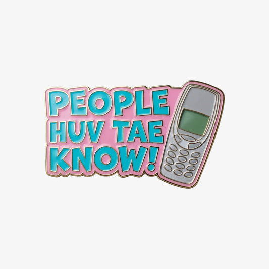 A soft enamel pin badge with the text People Huv Tae Know and an old fashioned mobile phone on pink background.